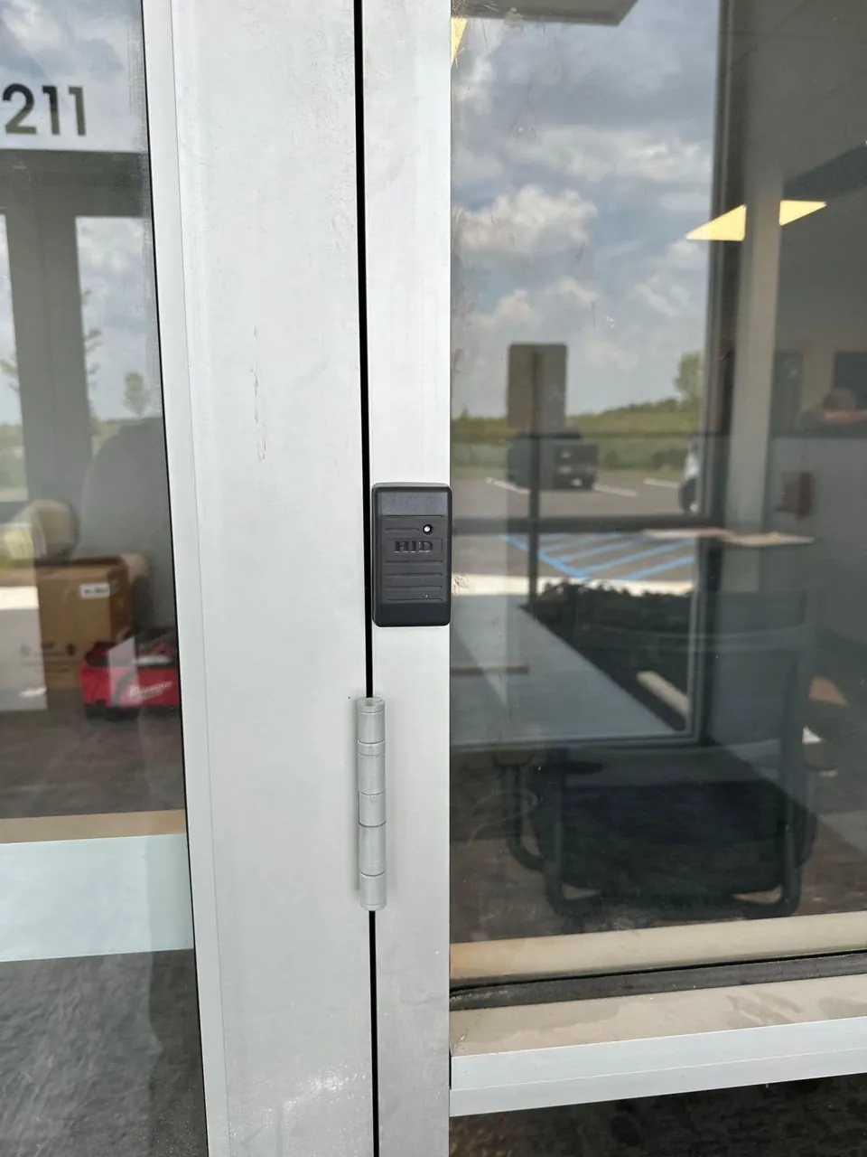 HID credential reader mounted on aluminum storefront door frame