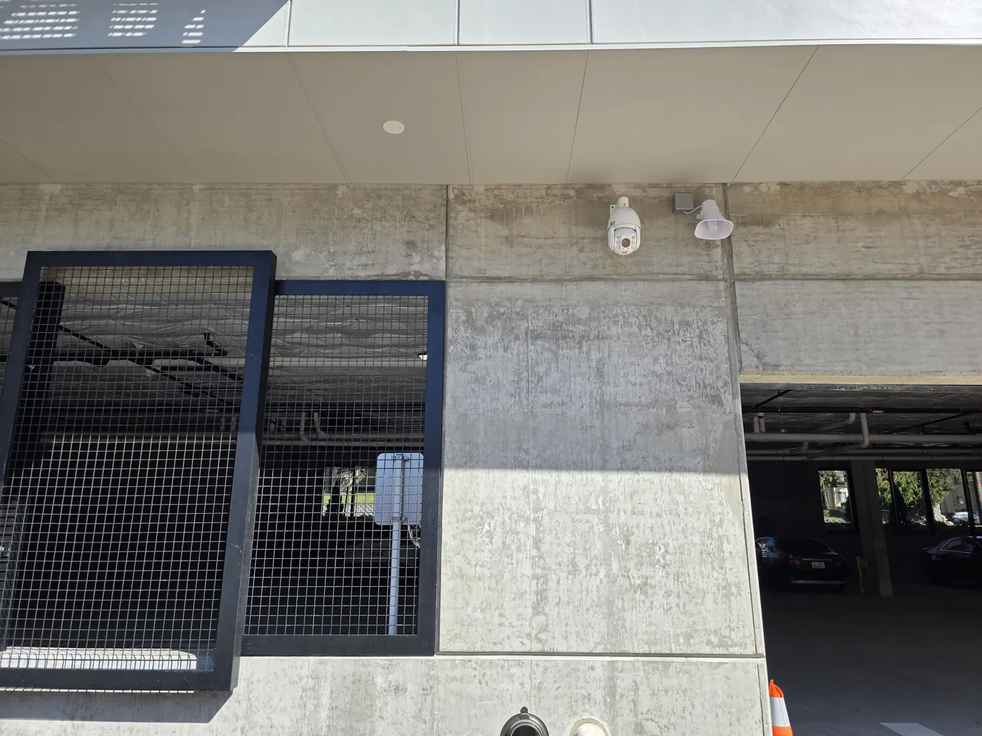 Two exterior surveillance cameras mounted on a commercial building wall