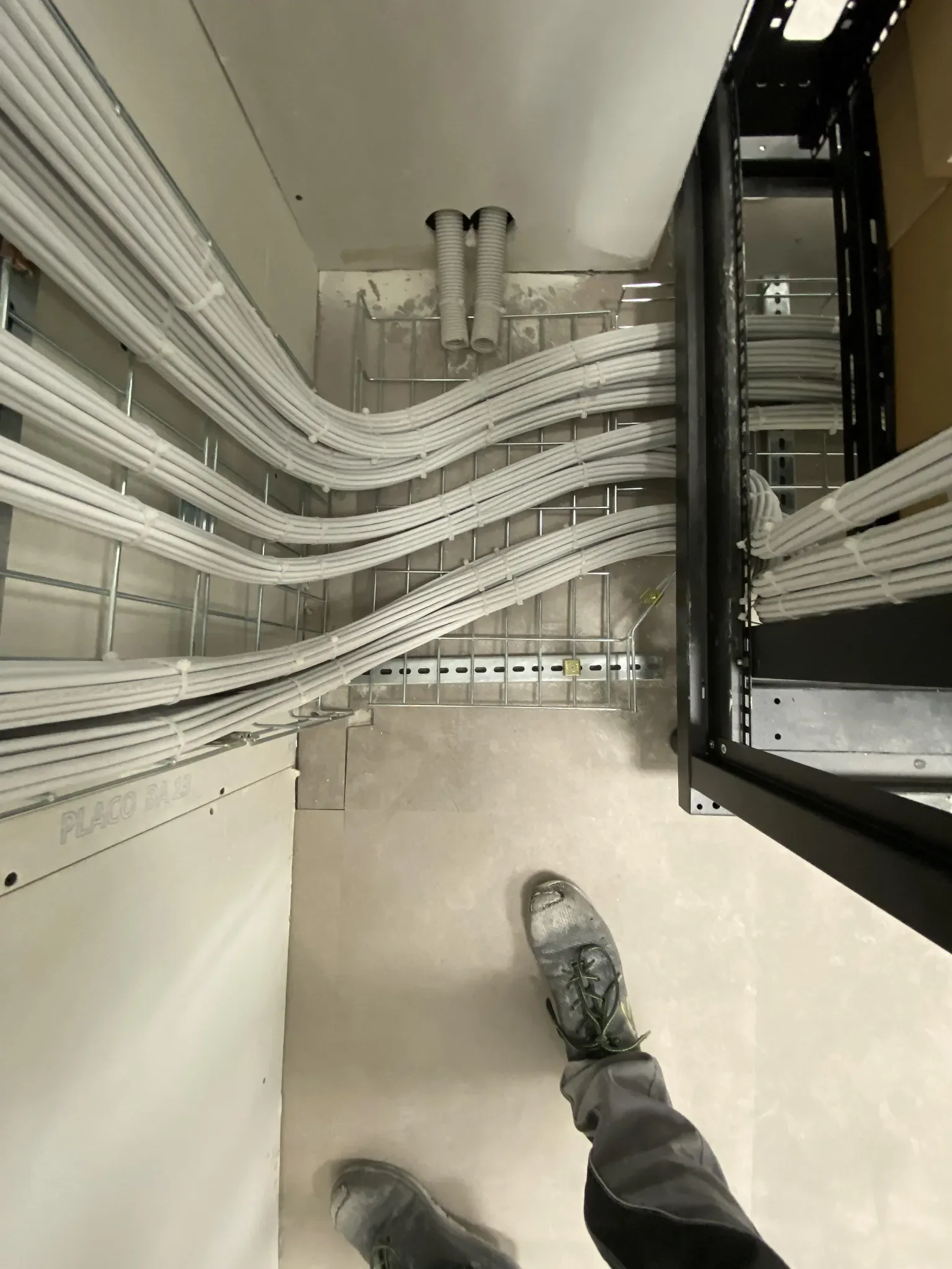 White structured cables neatly routed in cable tray toward rack